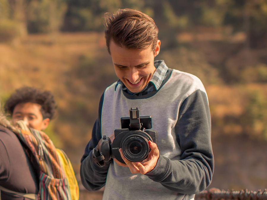 Corey Walker holding a camera, smiling.