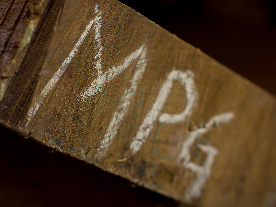 The letters "MPG" on the side of a piece of timber.