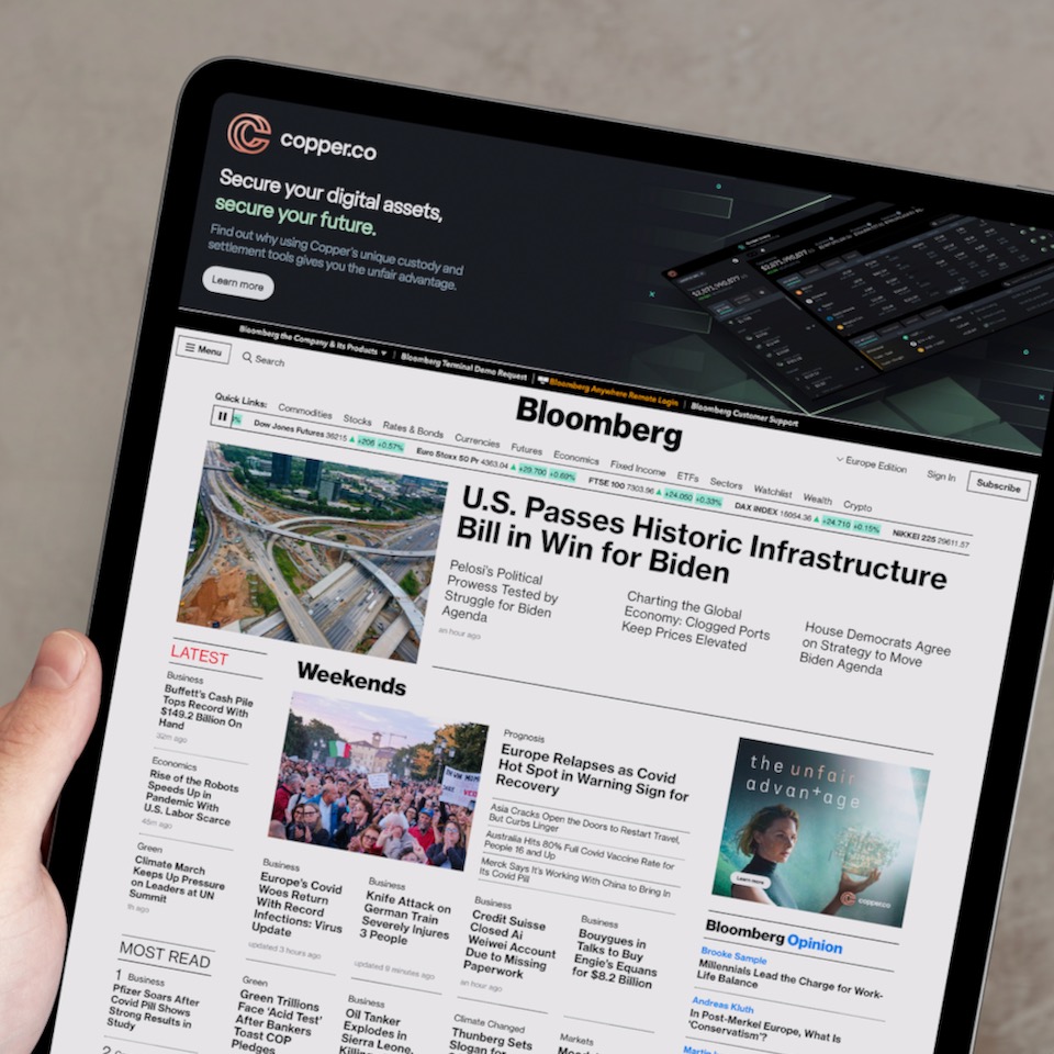 iPad showing the Bloomberg homepage with a Copper web banner advertisement.